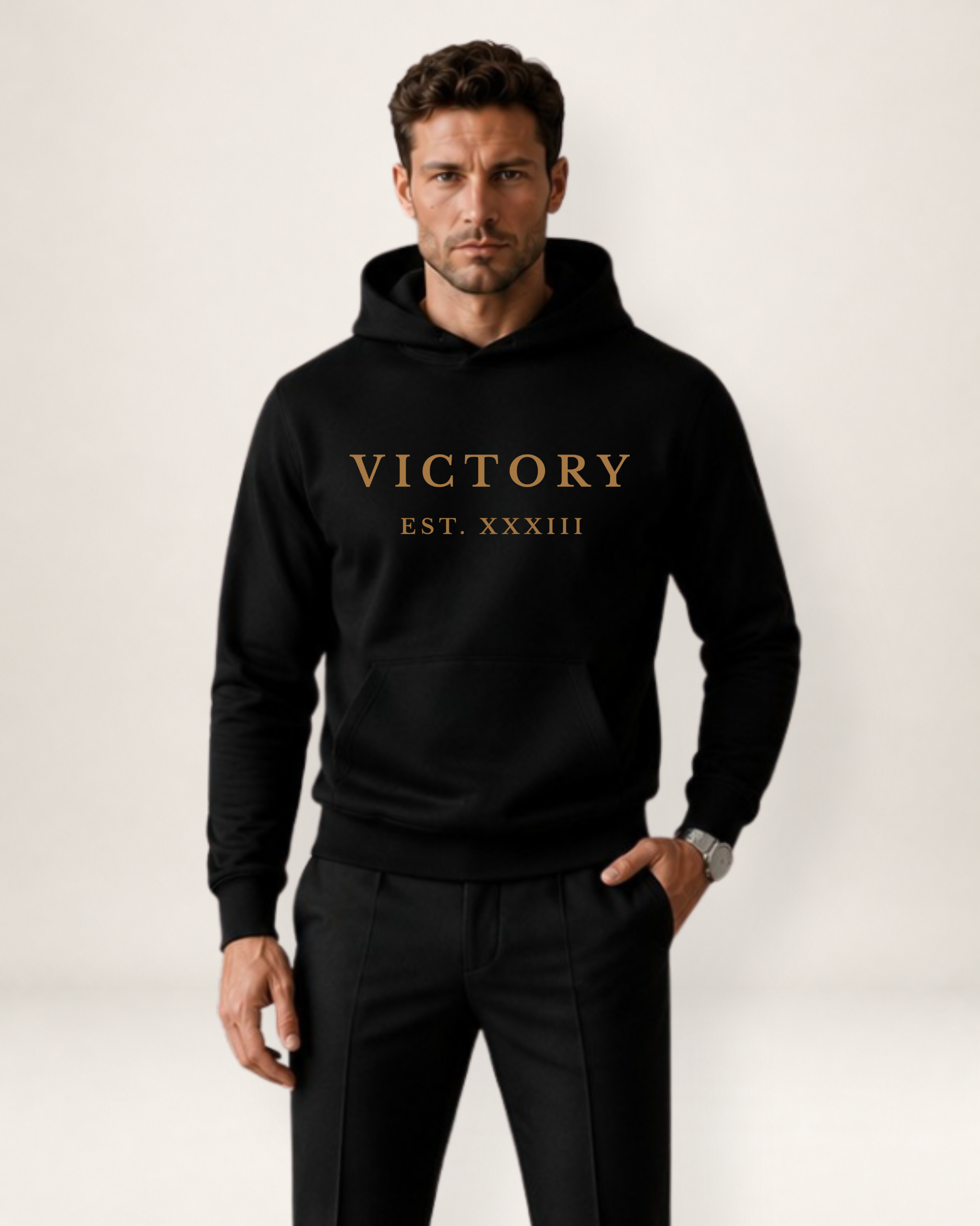 Man wearing a black hoodie with 'VICTORY EST. XXXIII' text on a white background