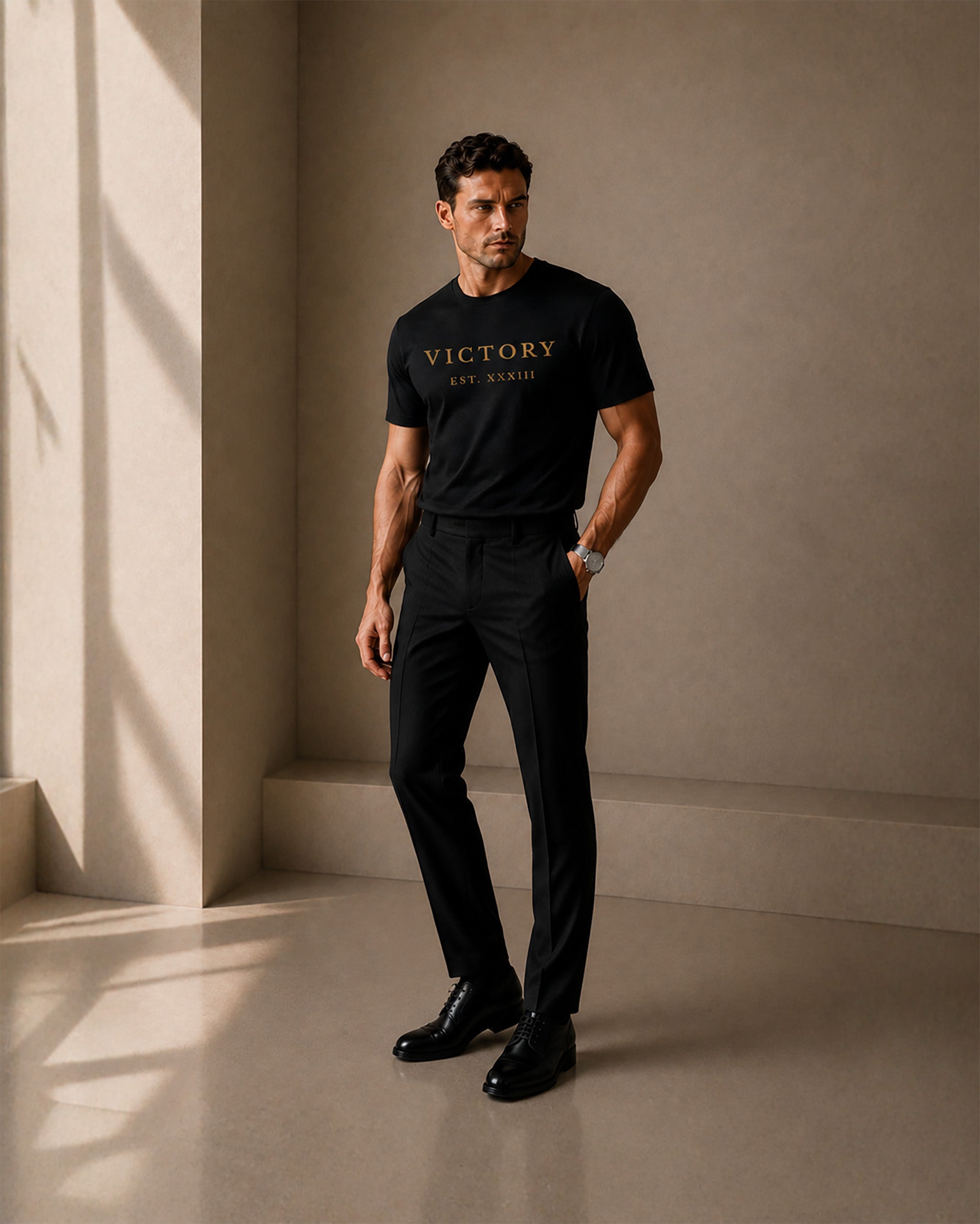 Man wearing a black t-shirt with 'VICTORY' text in a minimalistic setting