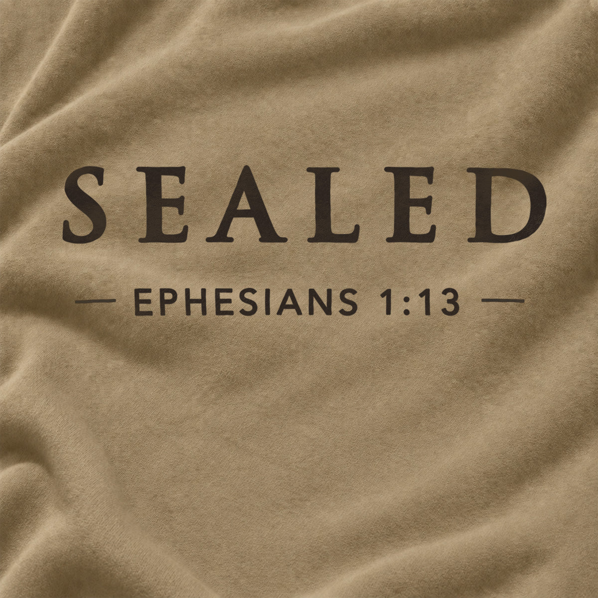A close-up of a textured tan fabric with dark brown printed text reading 'SEALED' and 'EPHESIANS 1:13' on a draped background.