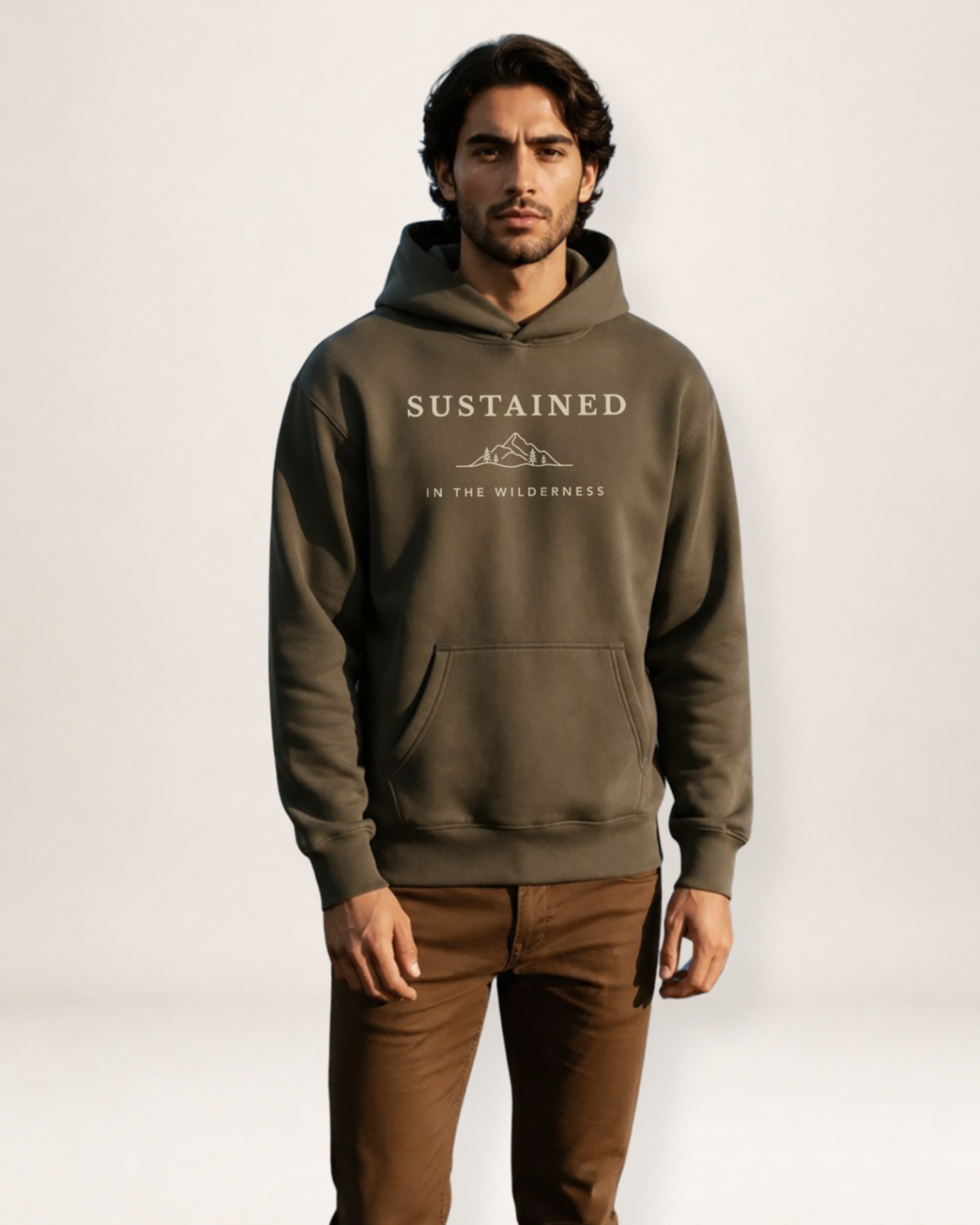 Man wearing a brown hoodie with 'Sustained in the Wilderness' text on a white background