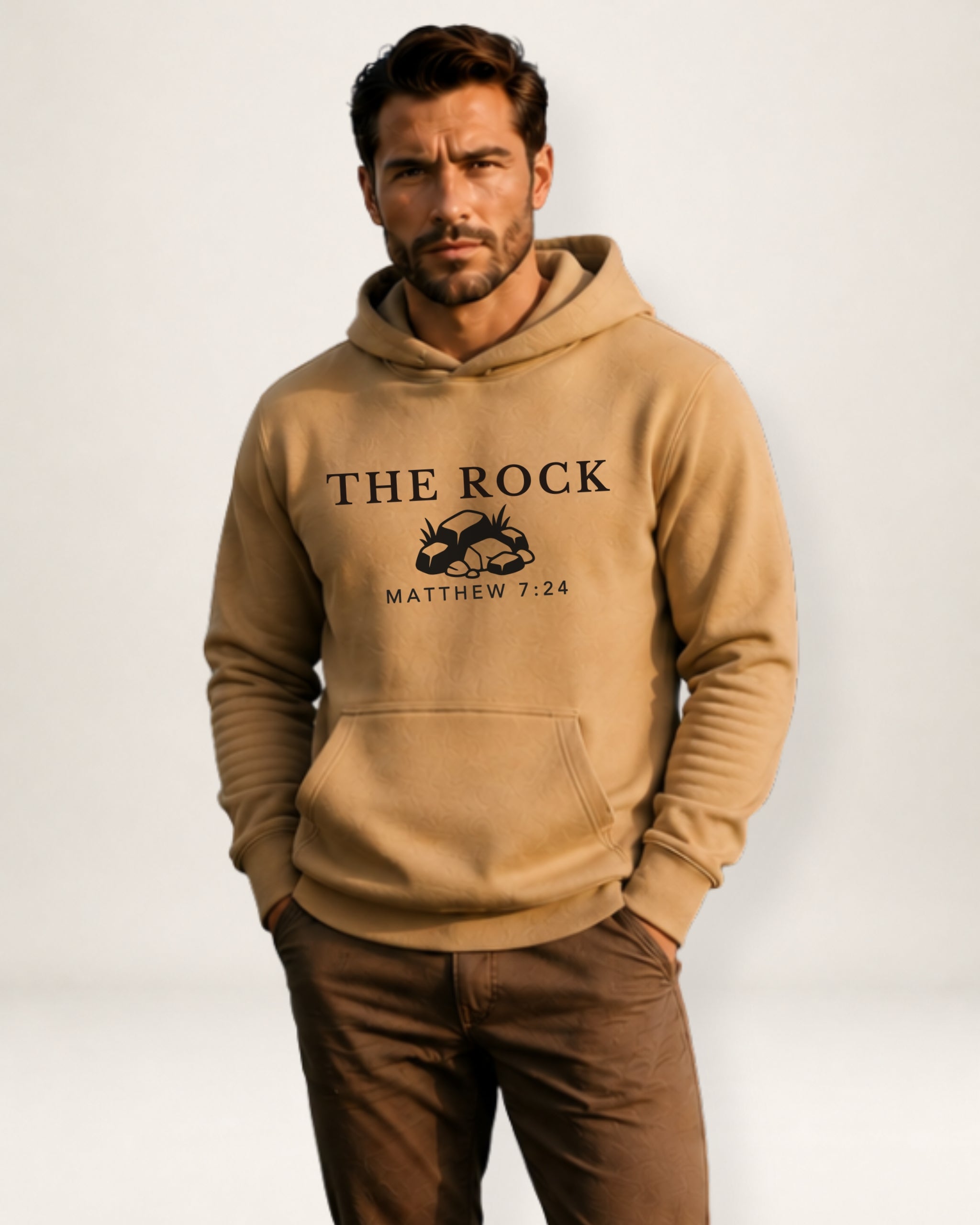 Man wearing a beige hoodie with 'The Rock' text and graphic on a white background