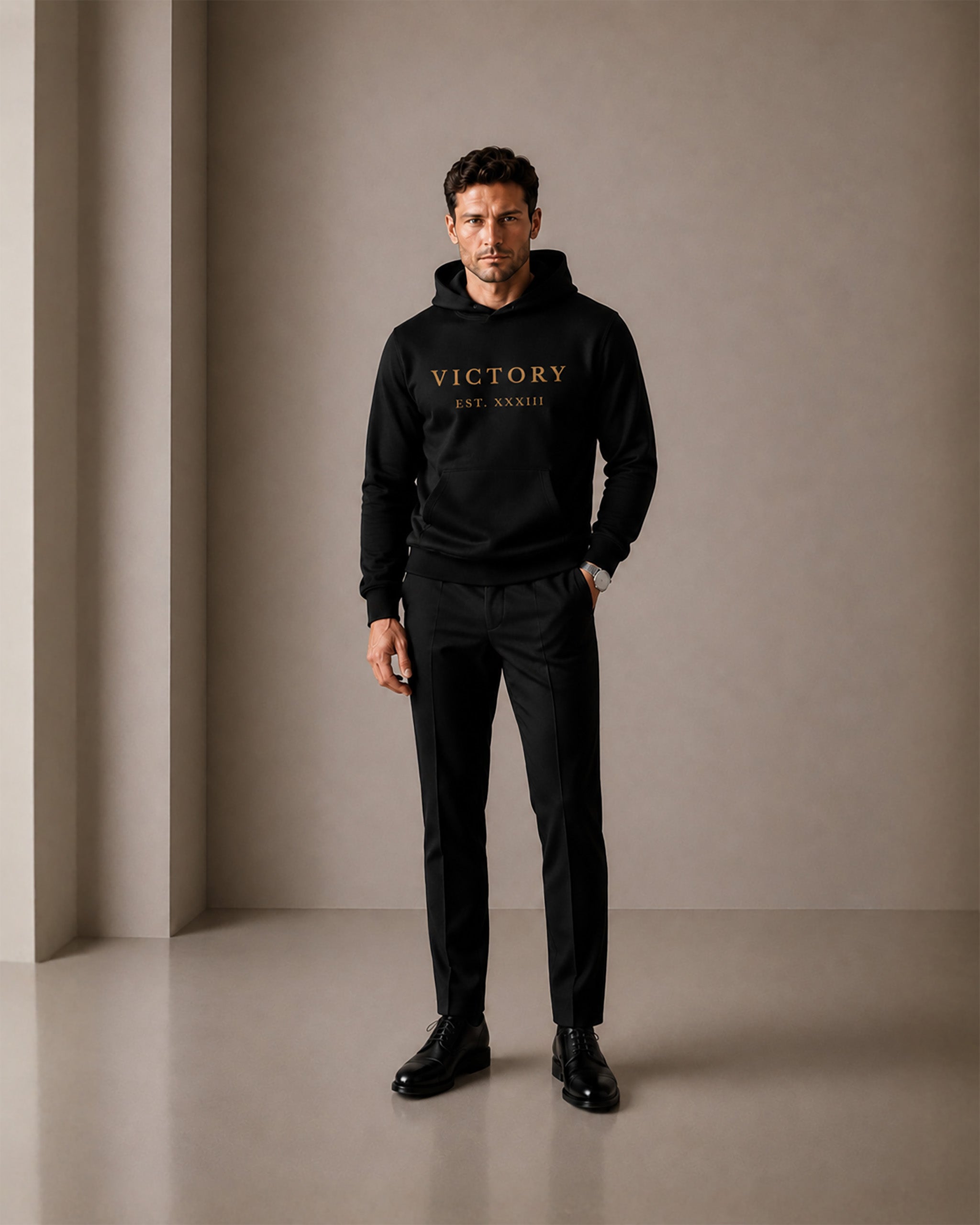 Man wearing a black hoodie with 'VICTORY' text, standing against a plain background