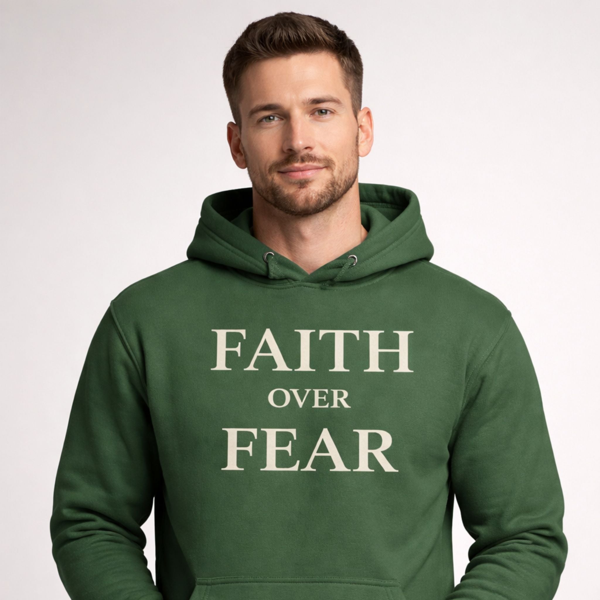 Man wearing a green hoodie with 'Faith Over Fear' text on a light gray background