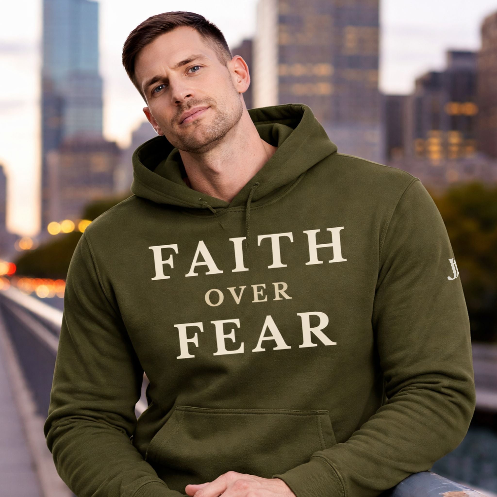 Man wearing a green hoodie with 'Faith Over Fear' text in an urban setting