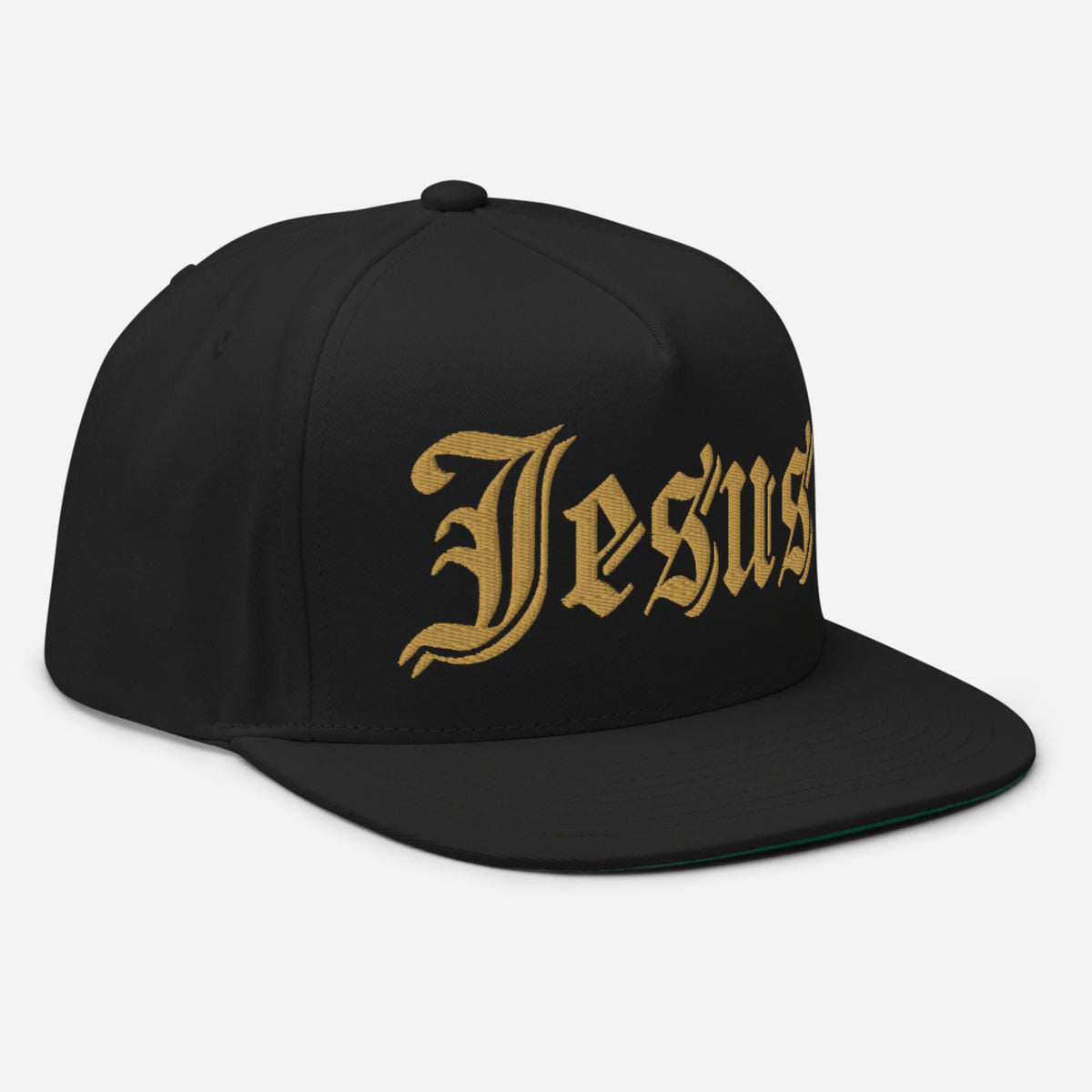 A black flat-brim snapback cap featuring the word 'Jesus' embroidered in a gold Gothic font across the front panels, set against a BLACK background.