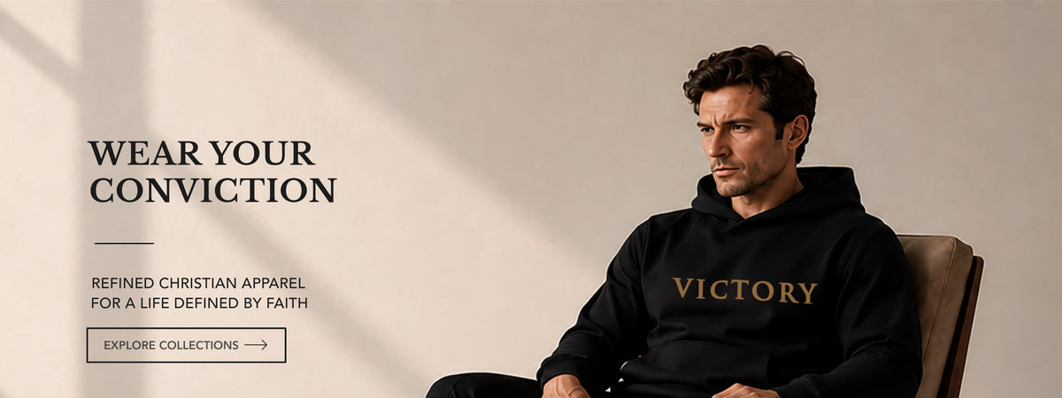 A man wearing a black hoodie with 'VICTORY' printed in gold across the chest, seated in a chair against a beige wall. Text on the left reads 'WEAR YOUR CONVICTION' with additional apparel copy and an 'EXPLORE COLLECTIONS' button.