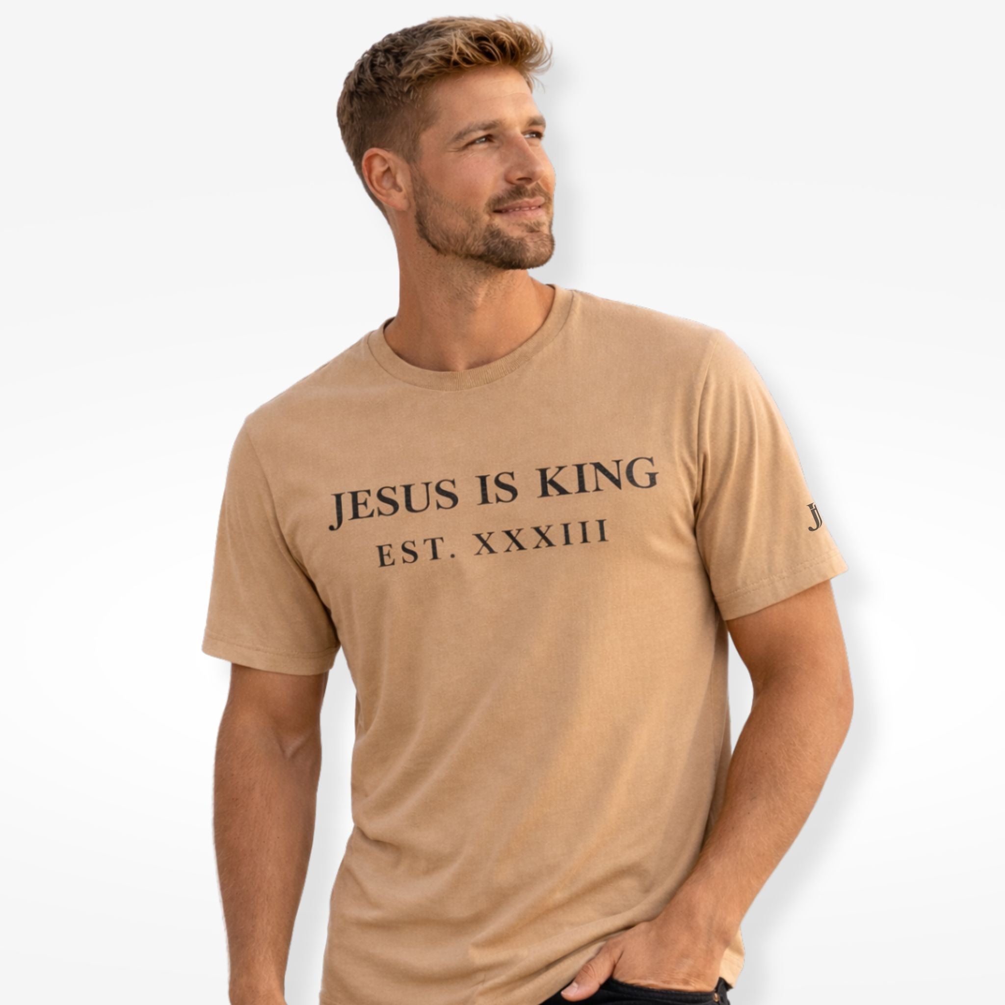 Man wearing a tan t-shirt with 'Jesus is King' text on a plain background