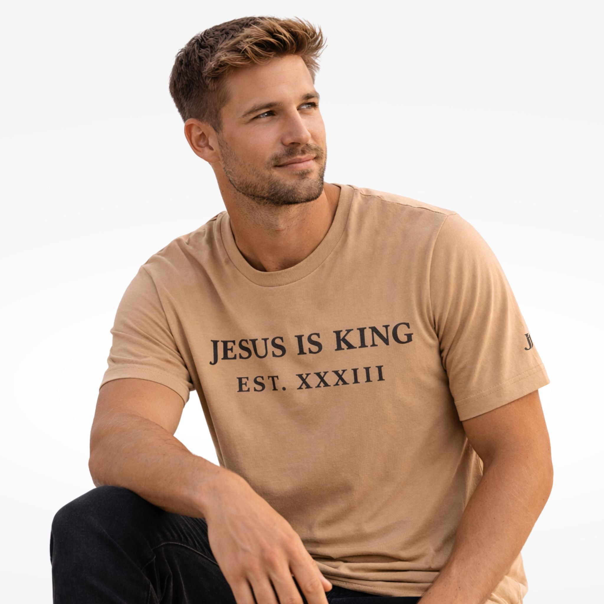 Man wearing a beige t-shirt with 'Jesus is King' text on a white background
