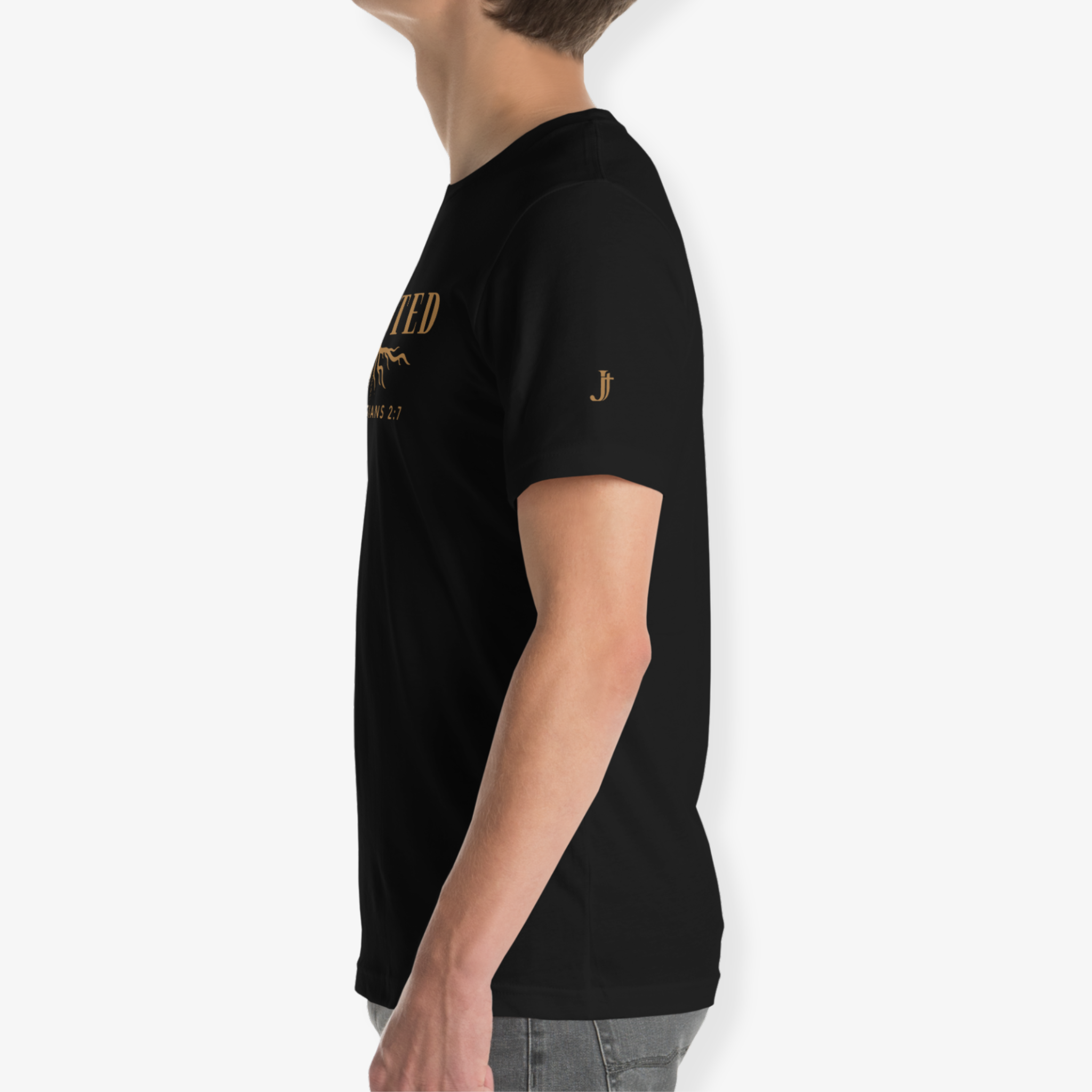 A side-profile view of a person wearing a black short-sleeve t-shirt with gold printed graphics on the chest and sleeve, paired with gray jeans, against a plain light gray background.
