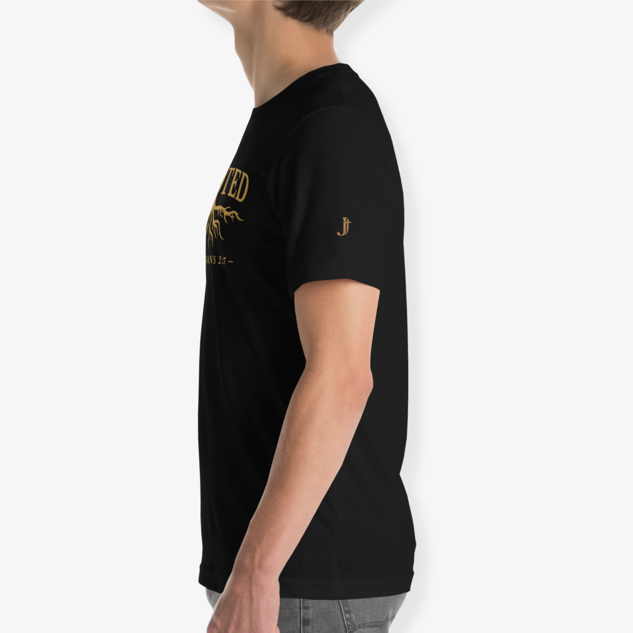 A side-profile view of a person wearing a black short-sleeve t-shirt with gold graphic text and a small gold logo on the sleeve, set against a plain light gray background.