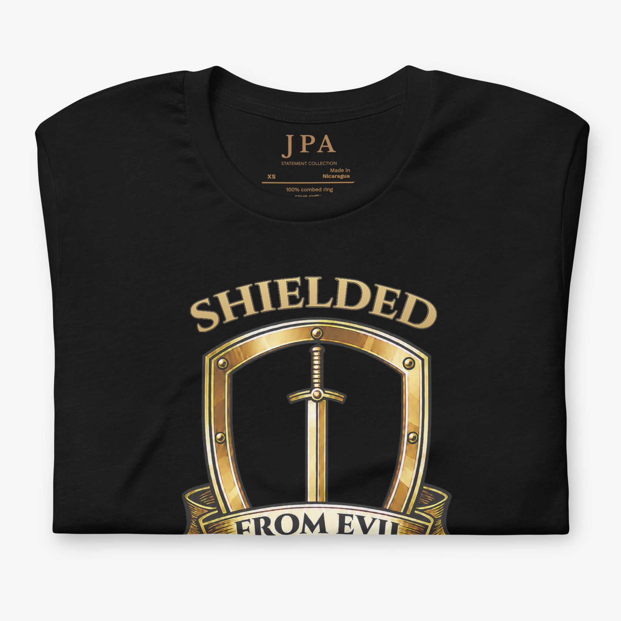 A black short-sleeve t-shirt with a gold graphic print on the front. The graphic features a metallic gold shield containing a sword, with the text 'SHIELDED' above and 'FROM EVIL' below.
