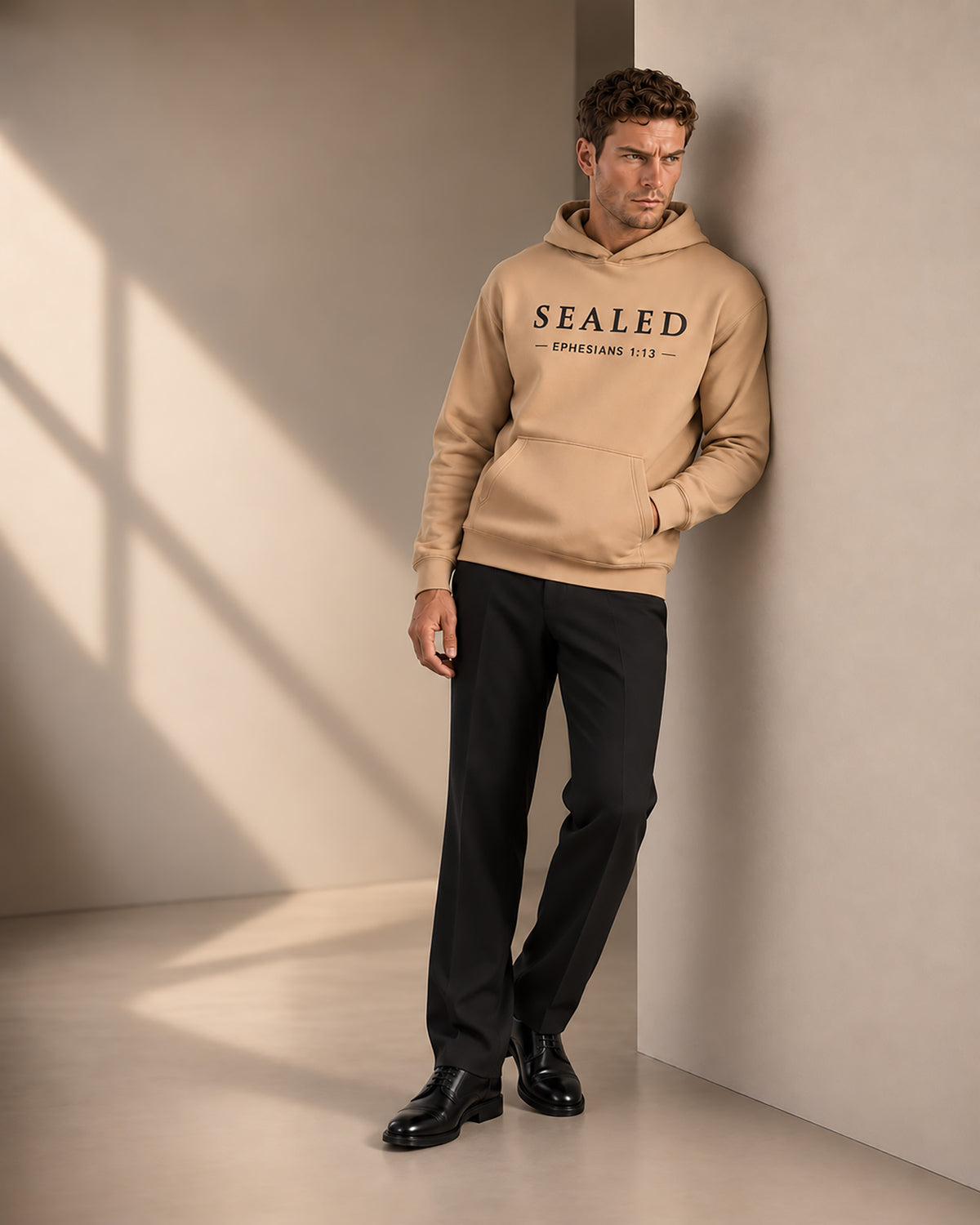 Lifestyle image of a male model wearing Sealed Hoodie in sand in a relaxed setting.
