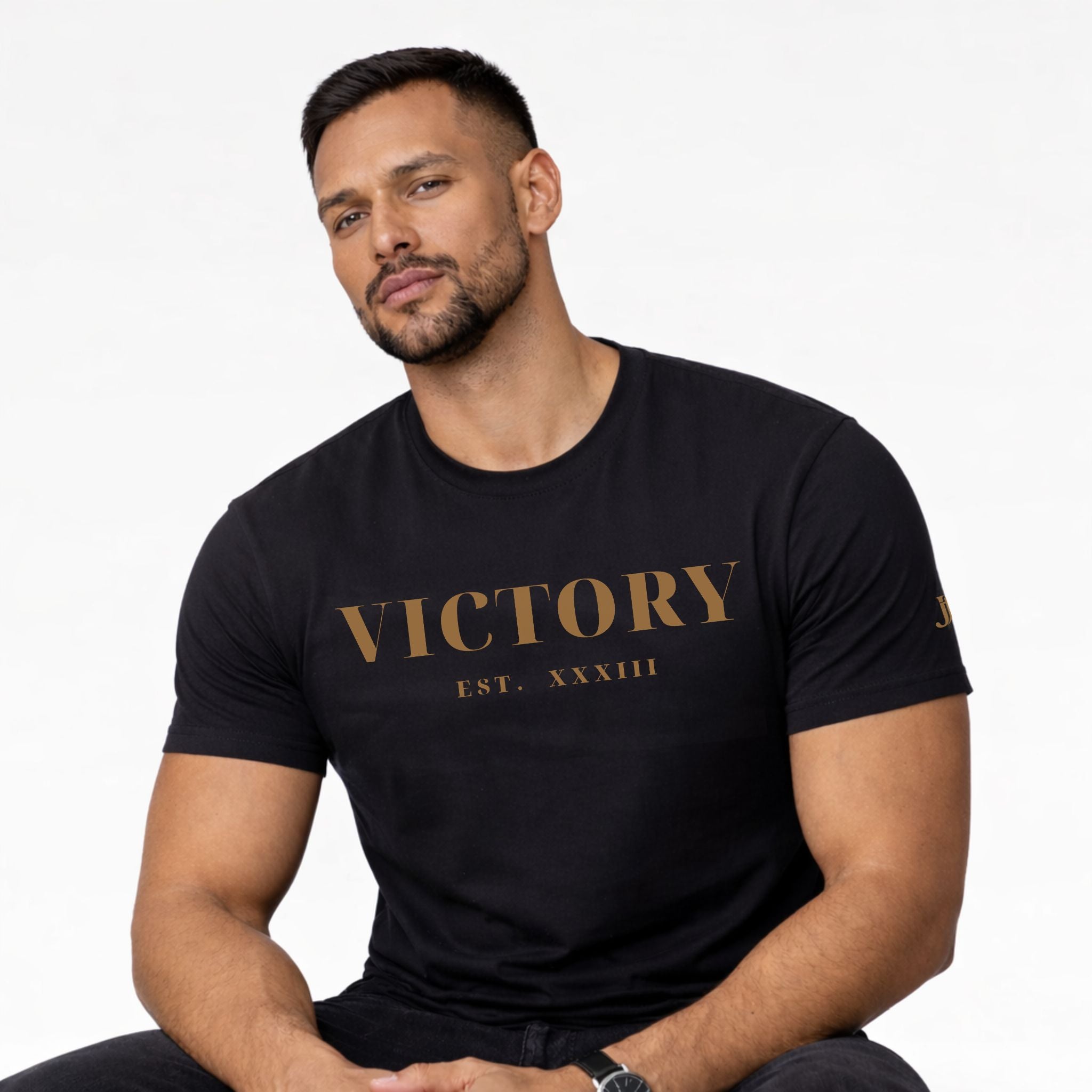 Man wearing a black t-shirt with 'VICTORY EST. XXXIII' text on a white background
