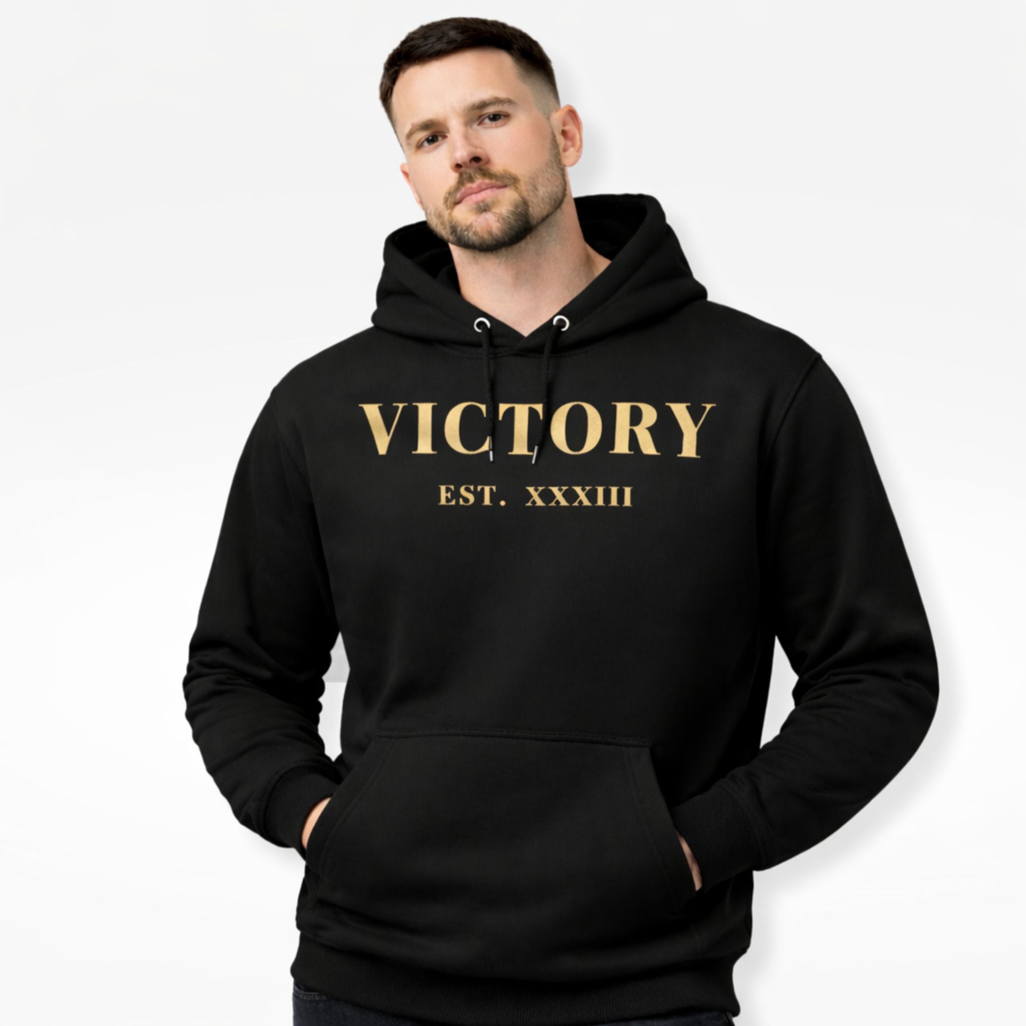 Man wearing a black hoodie with 'VICTORY EST. XXXIII' text in gold on a white background